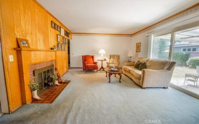 Family Room with full wall panelling and brick fireplace with mantel