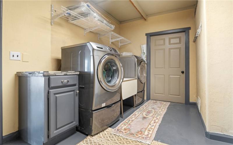 The laundry room includes washer/dryer, task sink and lots of storage