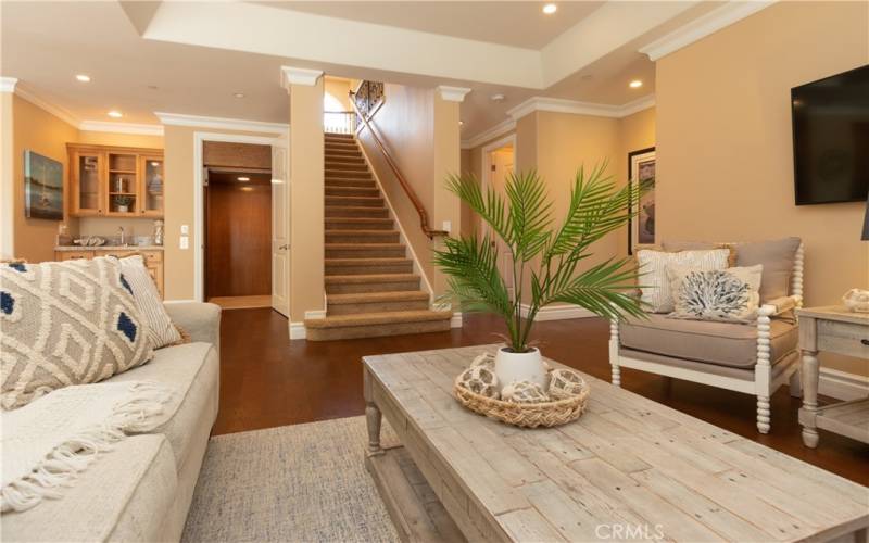 Stairs to upper levels, plus a bar area and elevator near the family room.