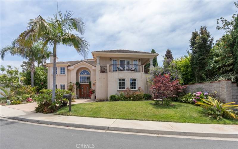 Spectacular curb appeal with a second level balcony and swaying palms.