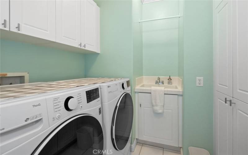 Upstairs Laundry Room has Utility Sink and Two Walls of Built-in Cabinets