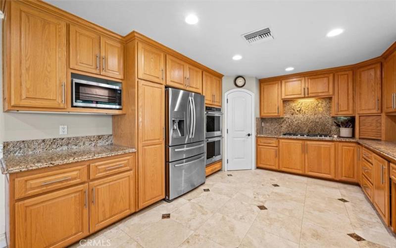 Huge upgraded kitchen is a chef's dream, complete with stainless steel appliances, a walk-in pantry, ample cabinets, and counter space