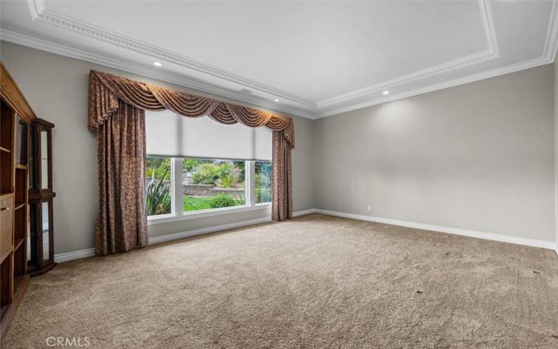 Living Room with soaring 11 ft coffered ceiling, remote-controlled blinds/shades, recessed lighting, and crown molding.