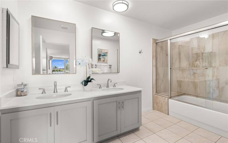 An updated double vanity primary bathroom with shower/tub combo