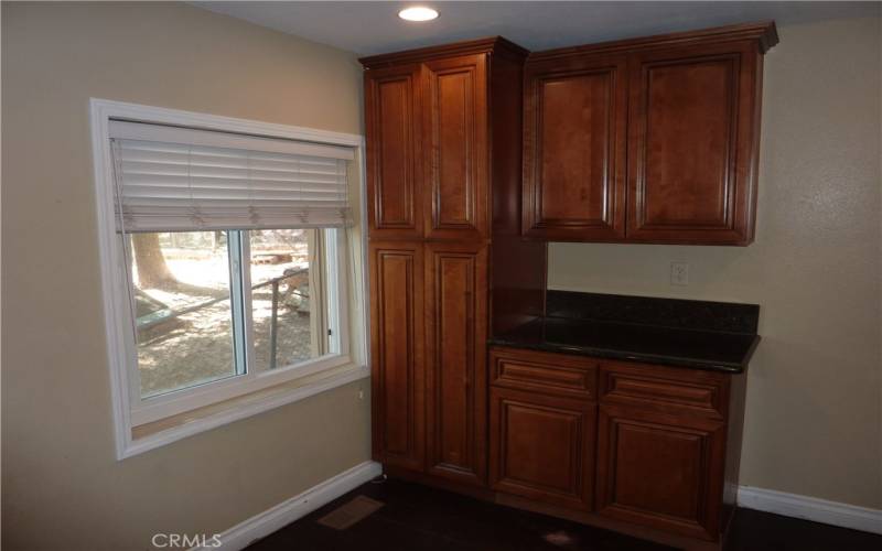 There are extra cabinets in the kitchen close to the refrigerator
