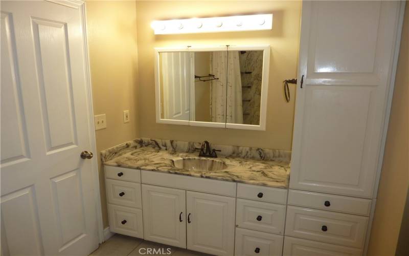 The master bathroom has lots of cabinets and storage