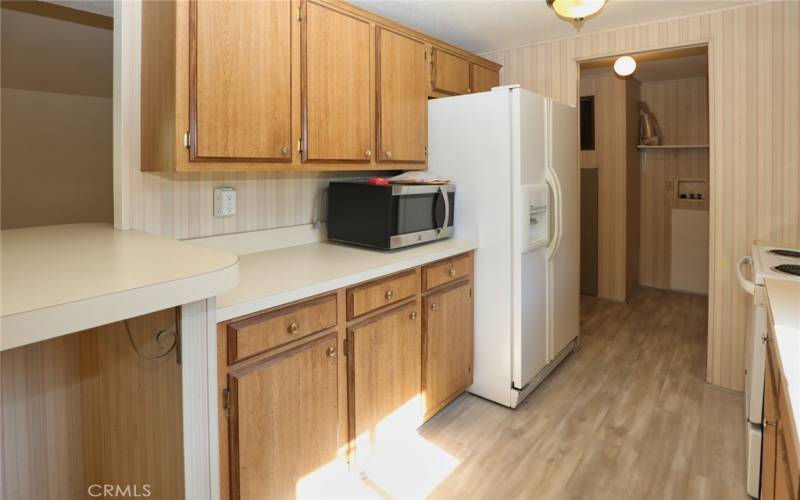 Kitchen with laundry room in the background.