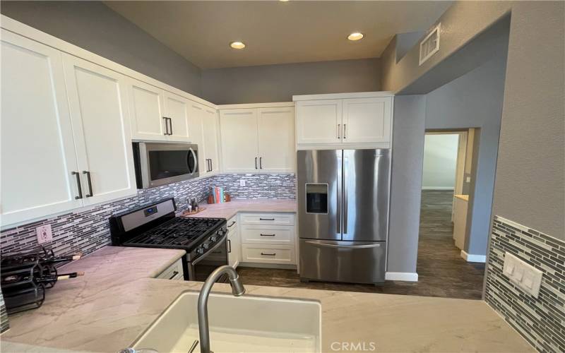 Remodeled kitchen with all stainless appliances included.  Quartz counters, under cabinet lighting, pot drawers and more.  Kitchen is  open to living room.