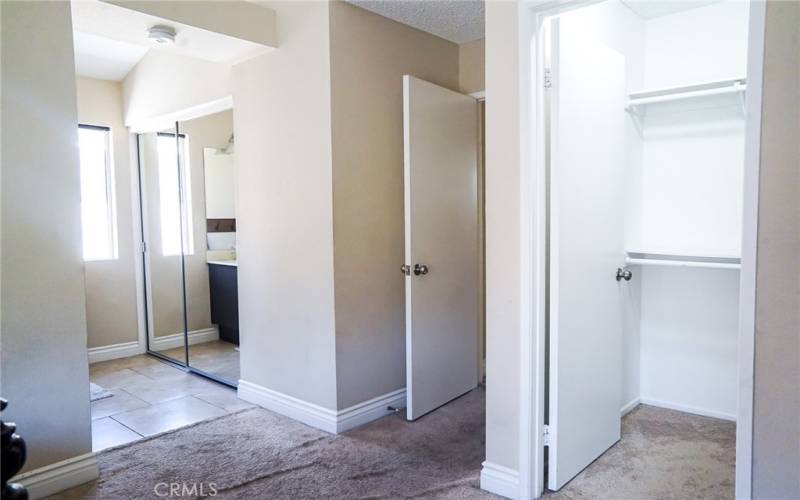 En Suite Walk in Closet and Mirrored Closet separated by private door.