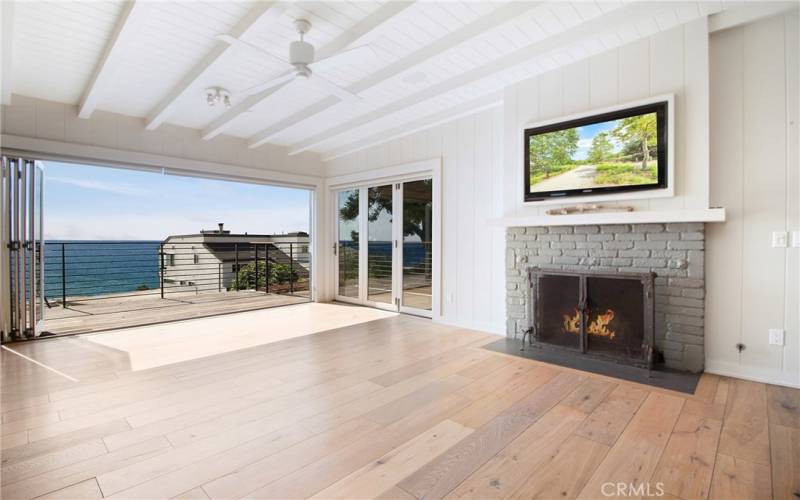 Family room/dining area with fireplace looking out onto front balcony.