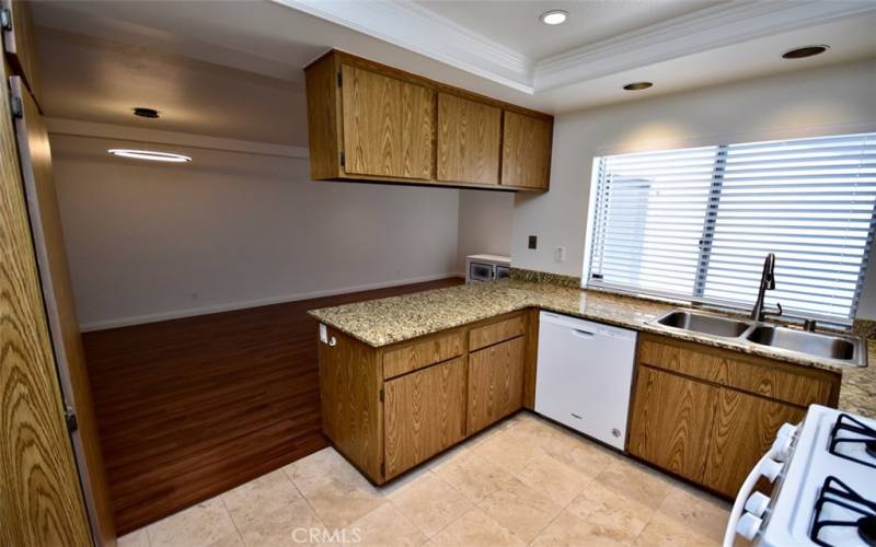 The kitchen exudes a contemporary charm with its spacious layout, nice appliances, and granite countertops, making it the heart of the home for both cooking and gathering.