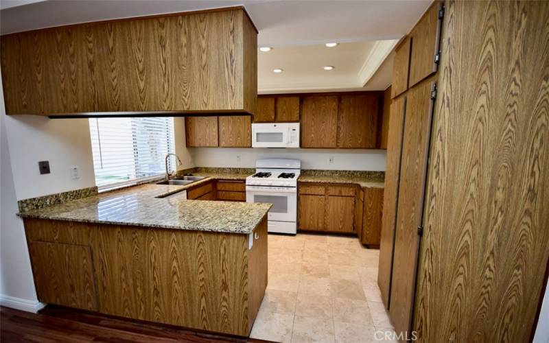 The kitchen is elegantly appointed with sleek granite countertops and a convenient breakfast bar, ideal for casual dining or socializing while cooking.