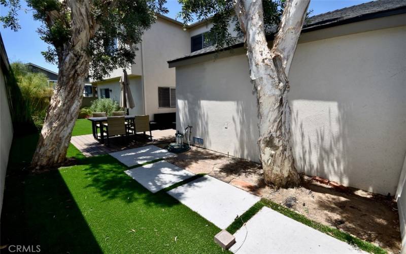 A well-maintained backyard featuring artificial turf provides a pristine, verdant space for outdoor activities and relaxation.