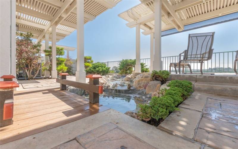 Koi Pond, Stamped Concrete, Low Maintenance Plants & Raised/ Shaded View Area.