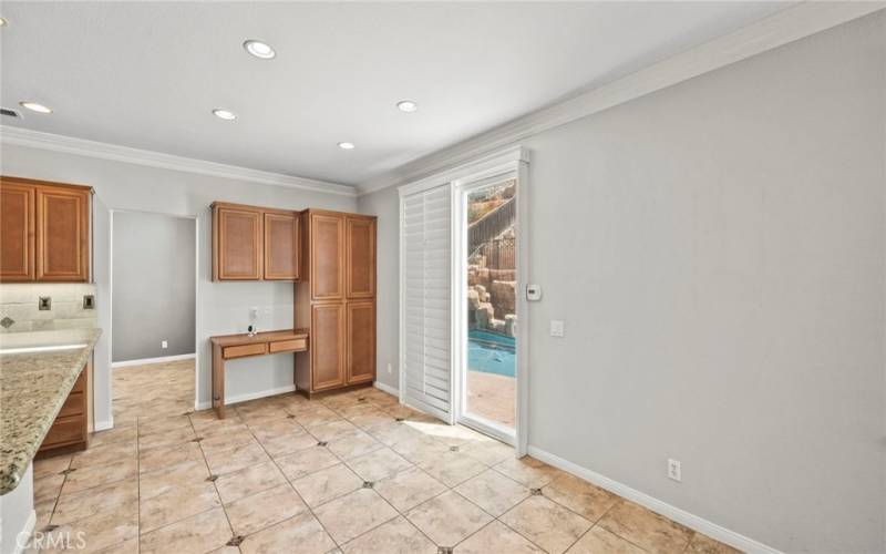 Office table and cabinets, Sliding glass door leads to a stunning entertainer’s backyard