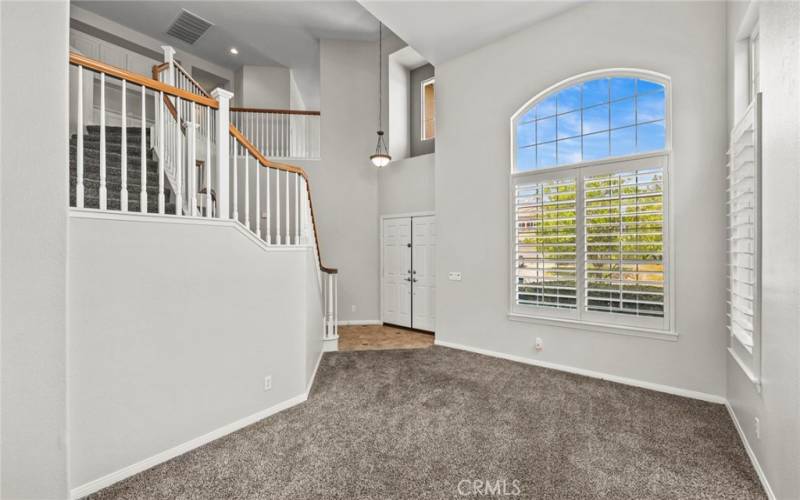 Sophisticated formal living room, designed to impress, features high ceilings and exquisite architectural details that set the stage for both intimate gatherings and grand entertaining.