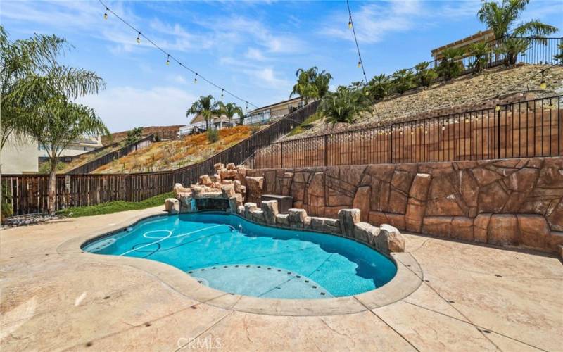 Experience the ultimate in outdoor luxury with this exquisite rock-designed pool, featuring a stunning grotto.