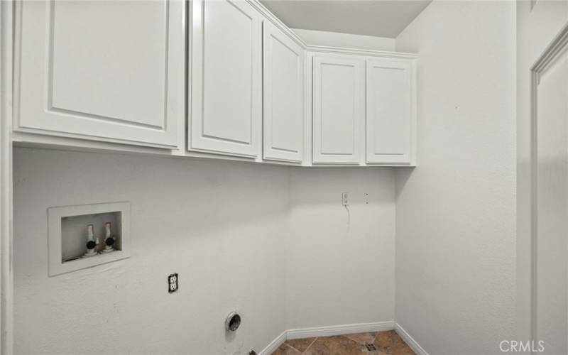 Main floor laundry room, featuring plenty of cabinet space to keep your home organized and clutter-free and combines practicality with style, seamlessly integrating into your daily routine.