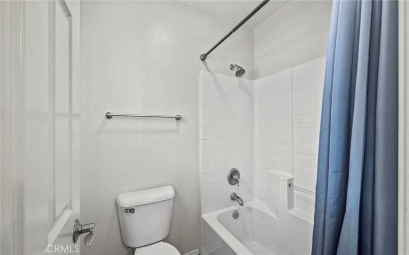 The upstairs full bath featuring a shower conveniently integrated inside the tub.