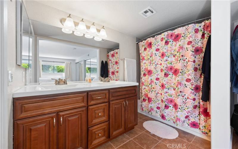 Master Suite restroom with dual sinks and tub and shower