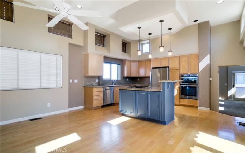 Entertainer's kitchen with center island with countertop seating, granite counters, ample cabinetry, stainless appliances, soraring ceilings, hardwood floors and more.