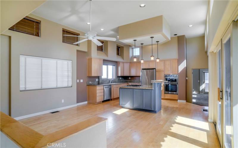 Dining room in the foreground featuring hardwood floors, soaring ceilings, great light and more.