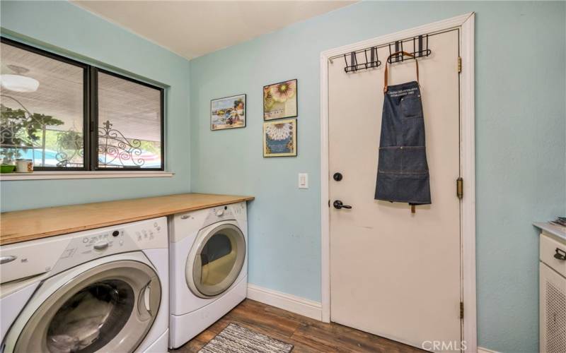 Laundry room off the hallway between primary and kitchen, opens to garage.