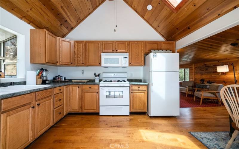 Large kitchen area with forest views and vaulted ceilings.