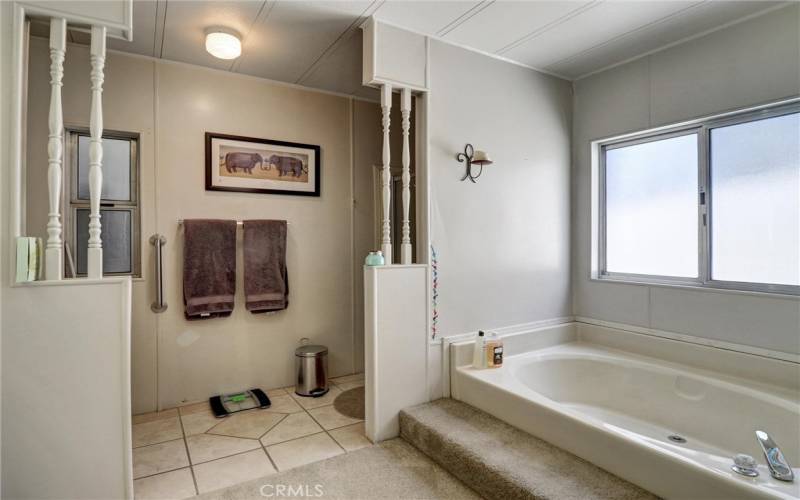 Primary bedroom bathroom features sunken tub