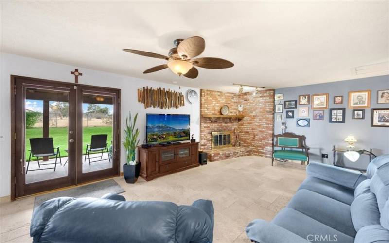 Primary Home - Large Family Room with Travertine Flooring, Large Brick Fireplace with Mantle and French Doors to the Large Covered Backyard Patio