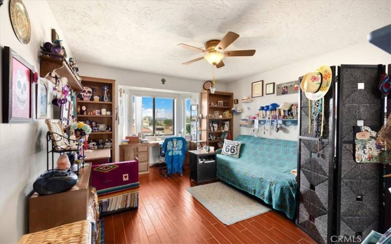 Primary Home - Bedroom #2 - Featuring Built in Bookshelves and Desk, Bay Window and Wood Look Tile Flooring