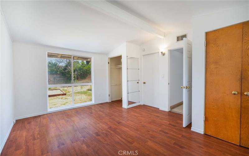 Primary bedroom with private full bath, view of  the yard & 2 double door closets.