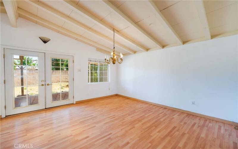 Dining area with open beam ceilings, chandelier & view of the yard