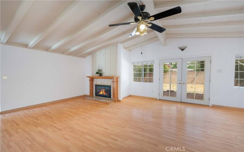 Living room with fireplace, laminate wood flooring, ceiling fan & French doors!