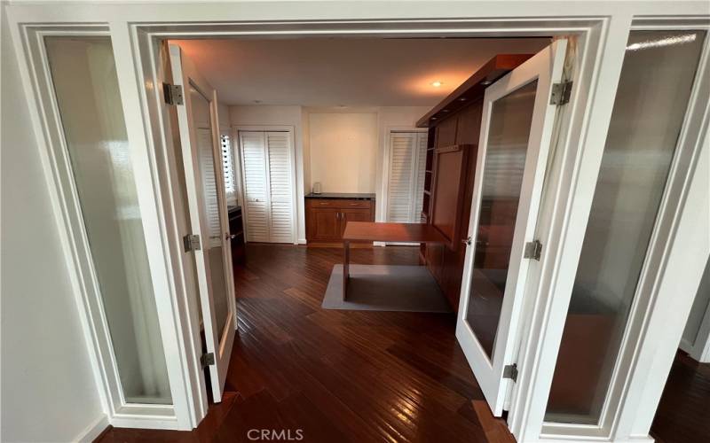 Private, rippled, glass doors separate the secondary den/secondary bedroom from the living room.