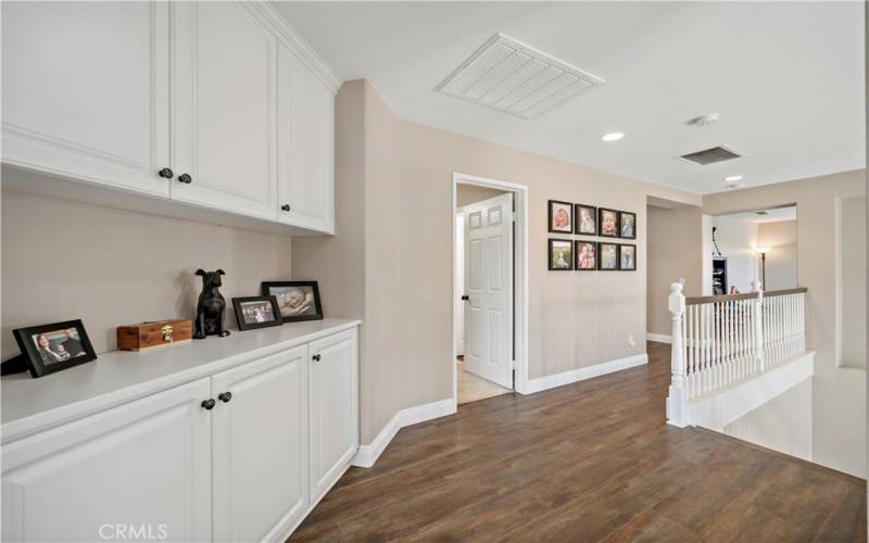 Upstairs hall with upgraded baseboards, laminate flooring. Linen storage and a whole house fan.