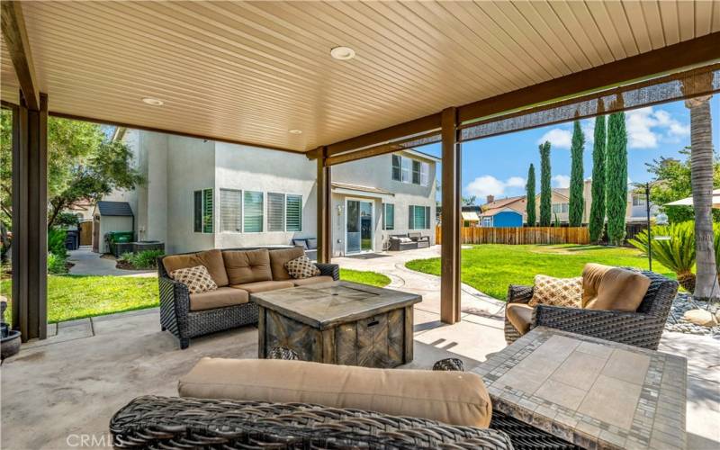 View from the covered patio, the smaller side yard is still large with storage shed and olive trees.