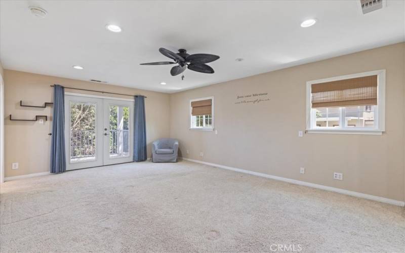 Primary bedroom showing French doors to balcony, another perspective.