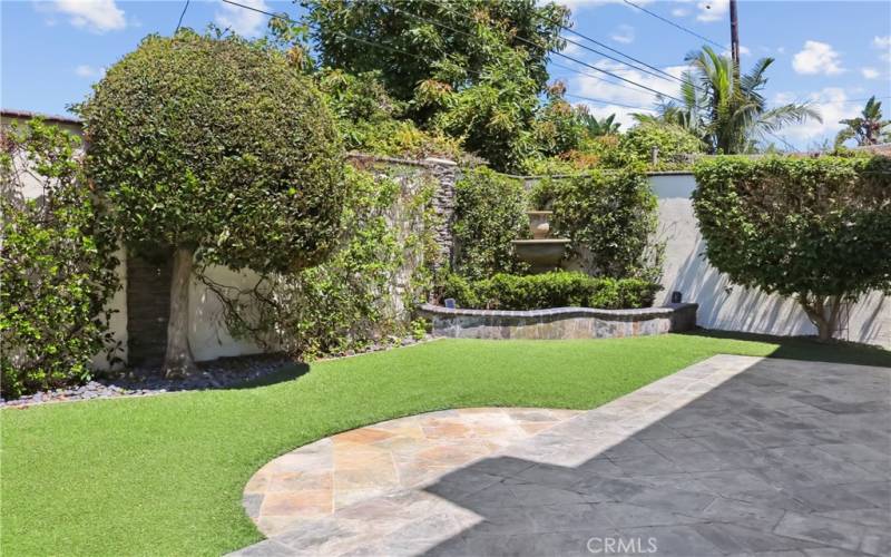 Well laid out and open back yard featuring babbling fountain and low maintenance artificial grass. Perfect for entertaining.
