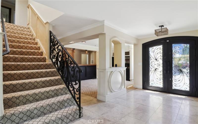 Entrance and stair case with beautiful decorative iron rails and features.