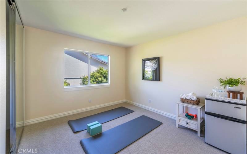 Fourth bedroom being used as a yoga/work out room, with mirrored closet doors.