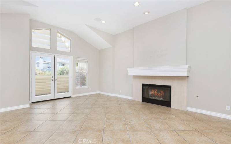 large living room with fireplace and dorrs leading to front patio