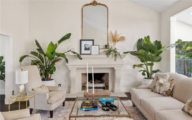 The Formal Living Room with soaring vaulted ceilings, a romantic custom fireplace, and wide plank French oak floors.