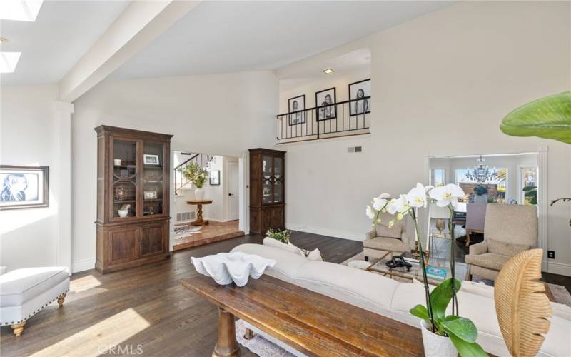 The formal living room with soaring vaulted ceilings, a romantic custom fireplace, and wide plank French oak floors.