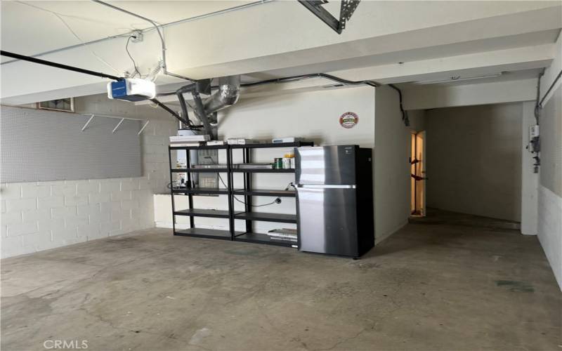 Shelving unit and refrigerator in garage.