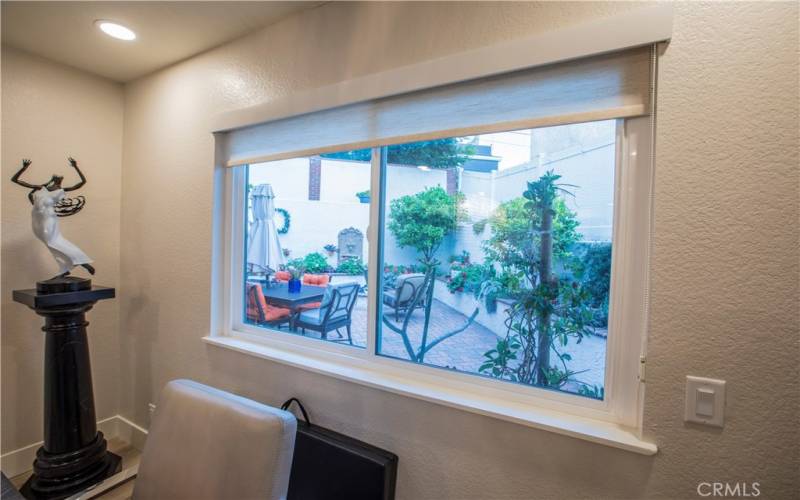 Window in the dining room with views of the beautiful patio area with firepit, water feature and outside BBQ area