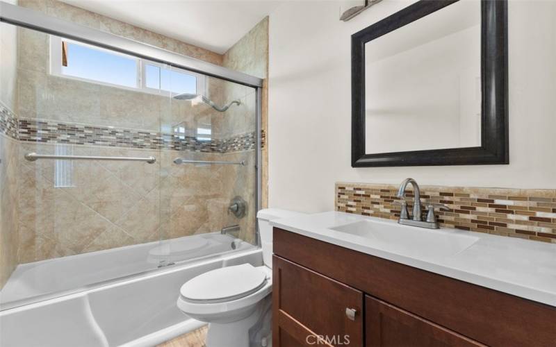 The bathroom features contemporary fixtures and a clean, fresh design.