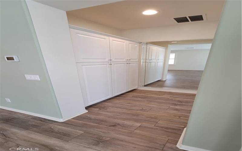 Hallway with storage that leads to the primary bedroom