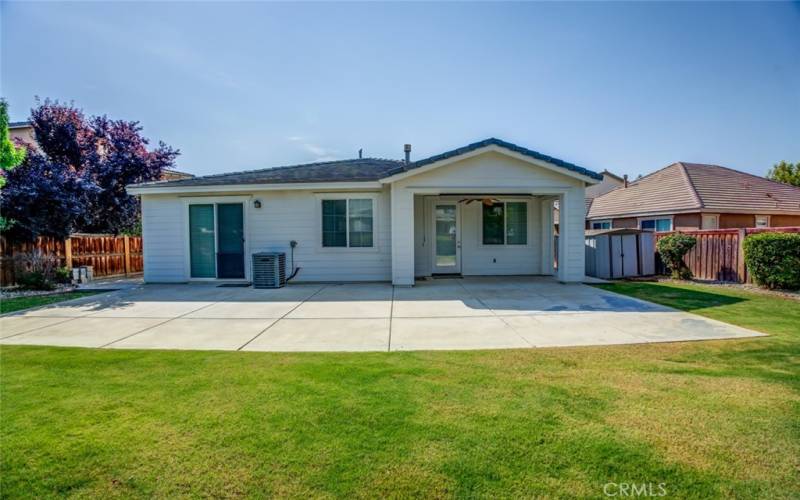 The large backyard is an entertainer’s dream with a patio and extended concrete area, perfect for BBQs and relaxation.