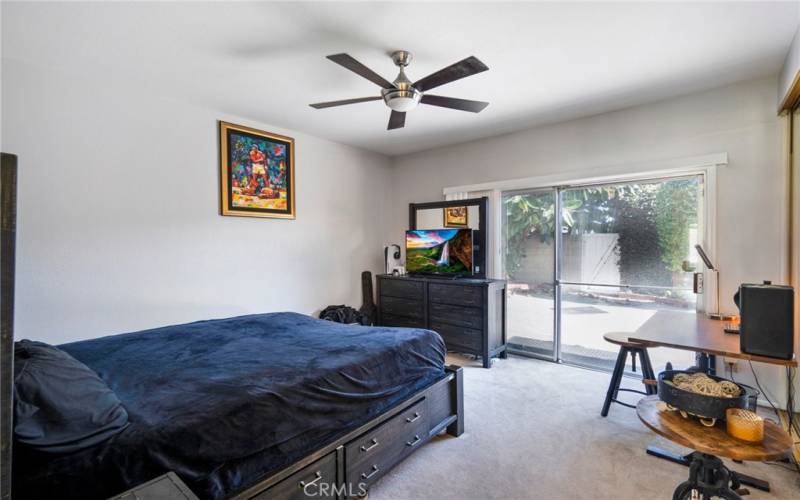 Main Floor Primary Suite with fresh interior paint, ceiling fan, entry to background